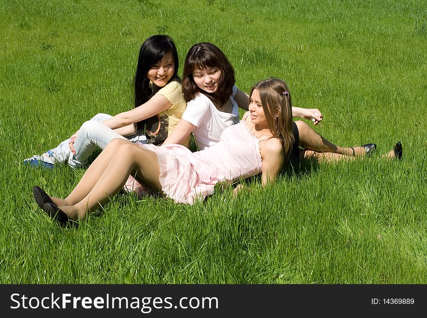 Three girls sitting on grass