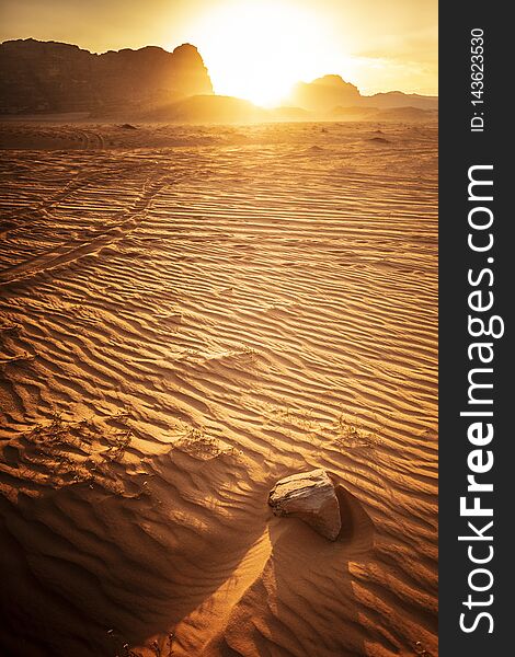 Landscape taken at the time of sunset, wadi rum desert, jordan, detail of sand dunes and rock in the foreground. Landscape taken at the time of sunset, wadi rum desert, jordan, detail of sand dunes and rock in the foreground