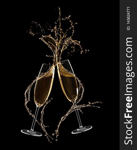 Glasses of champagne clinking together and splashing on black background