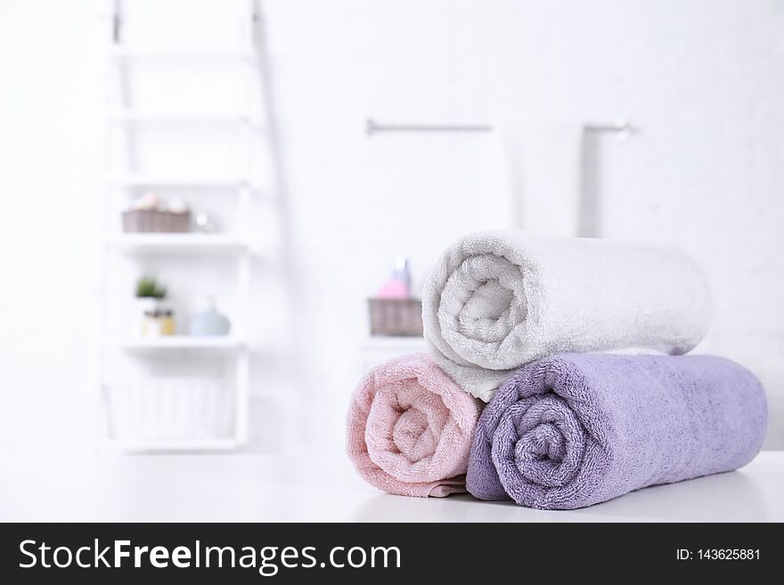 Rolled tidy towels on table in bathroom