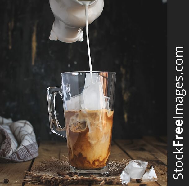 Ice coffee in a glass on wooden background