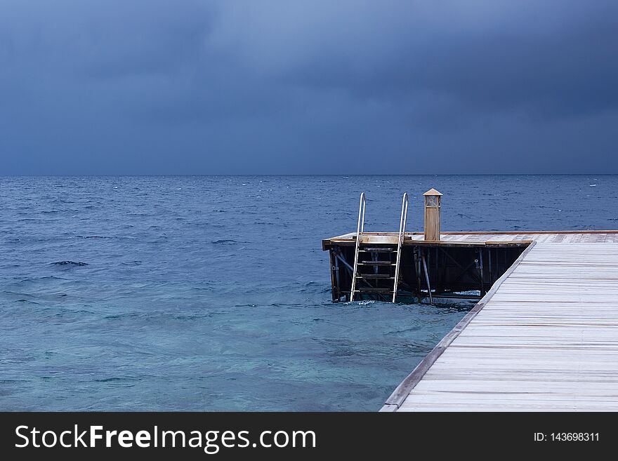Perspective view of a wooden pier on the tropical seashore   sea with turquoise water