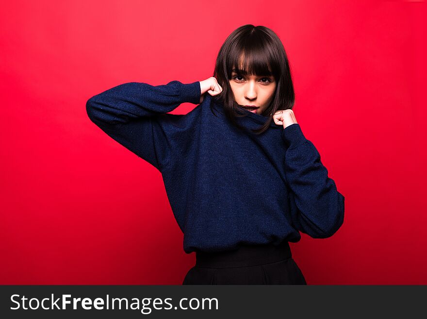 Cheerful Beautiful Young Woman In Sweater Over Red Background