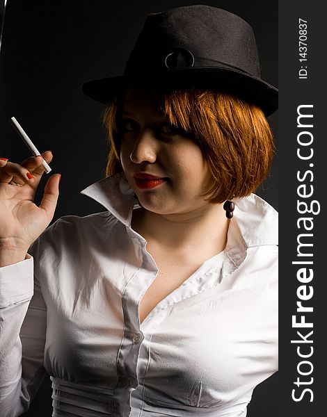 Beautiful girl with cigarette in black hat. Beautiful girl with cigarette in black hat