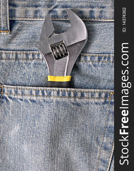 Adjustable spanner in a blue jean pocket. Adjustable spanner in a blue jean pocket