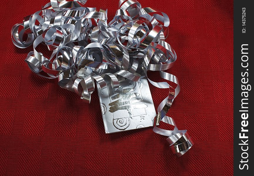 Silver ribbon and tag on red background. Silver ribbon and tag on red background