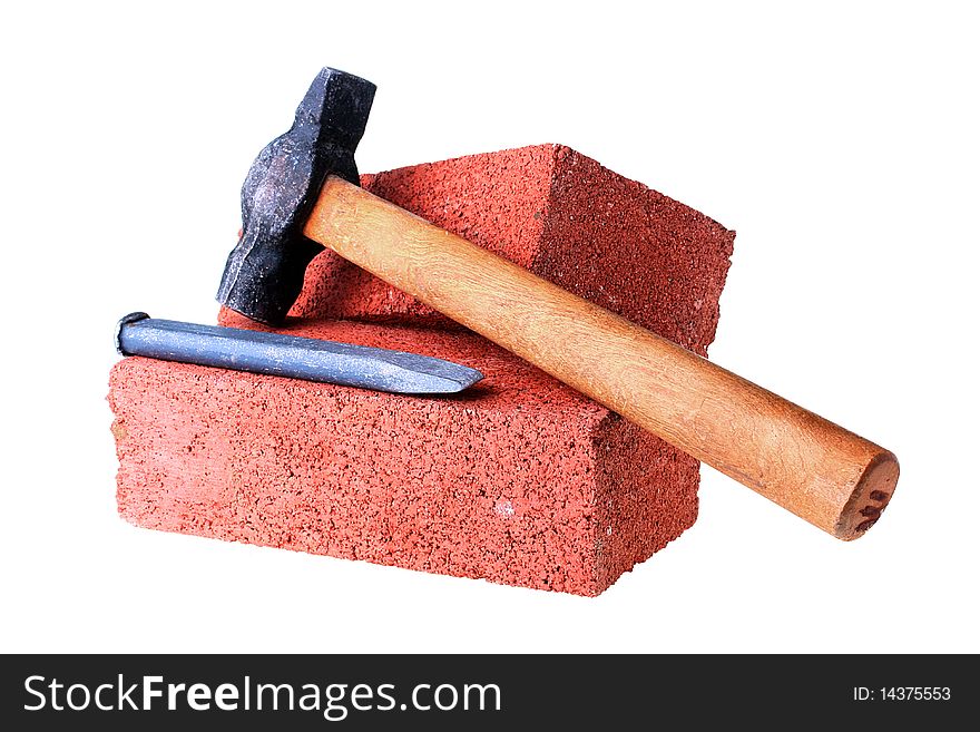 Building materials and tools: a chisel and a hammer with a brick from red clay.