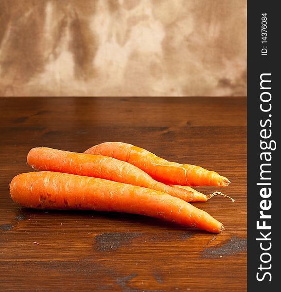 Photo of wonderful carrots putted on a wood table