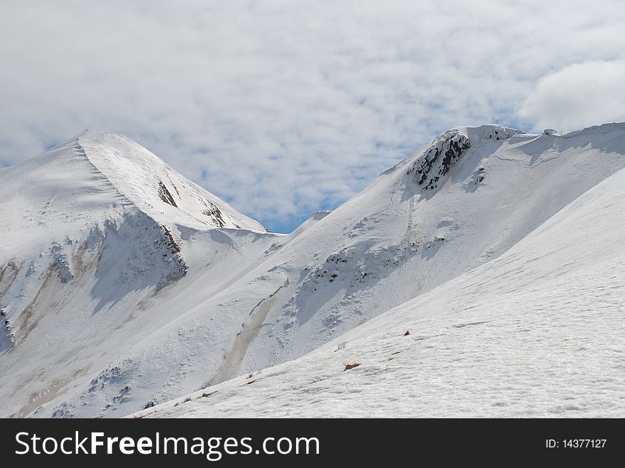Winter mountain top in a landscape with a white slope. Winter mountain top in a landscape with a white slope