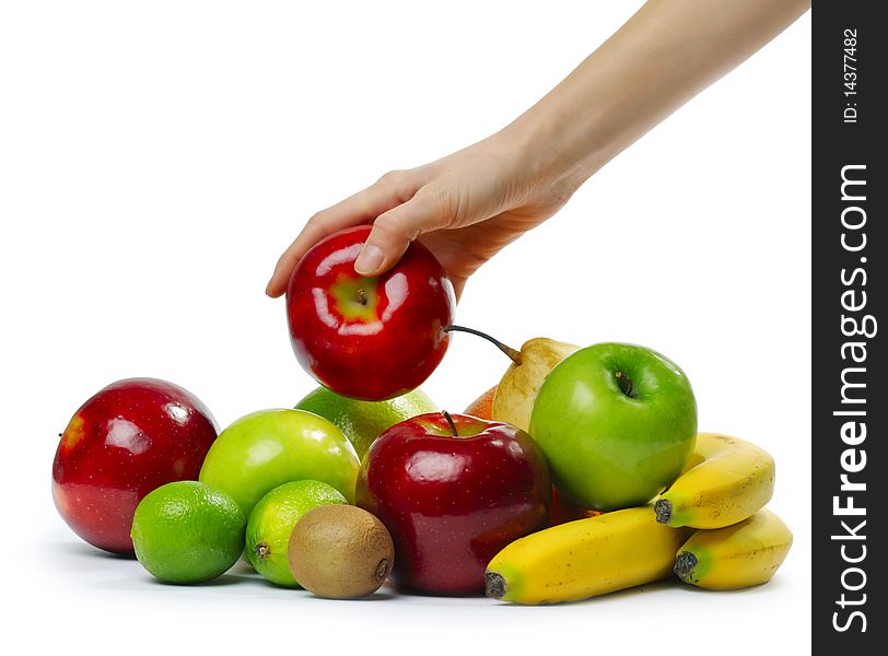 Hand with apple over heap of fruits