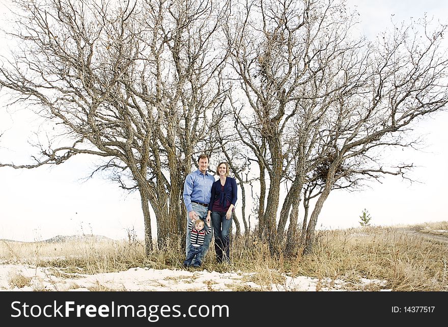 Happy family standing together in front of trees in nature