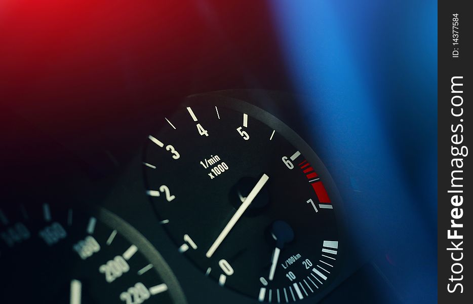 Scales of devices on a car dashboard with colored lights