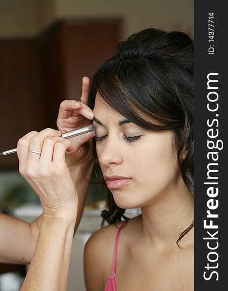 Attractive young brunette woman having make up put on, eyeshadow. Attractive young brunette woman having make up put on, eyeshadow