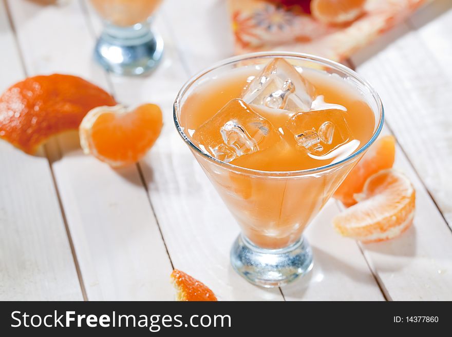 Clas of tangerine cocktail on wooden table top