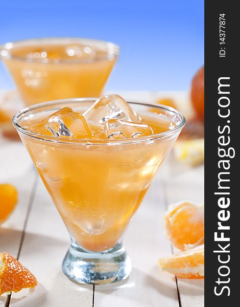 Tangerine cocktail on wooden table top and blue background