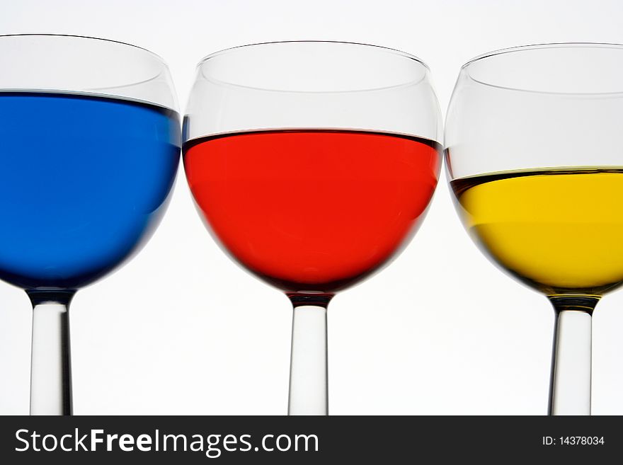 Three wine-glasses with drinks on a white background