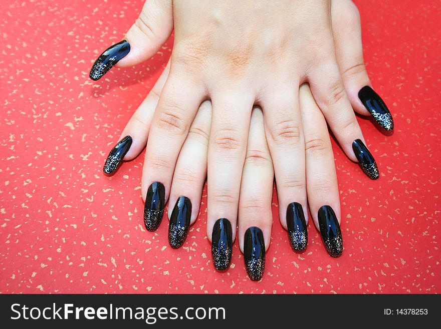 Woman hands with nail art isolated on spotted red background.