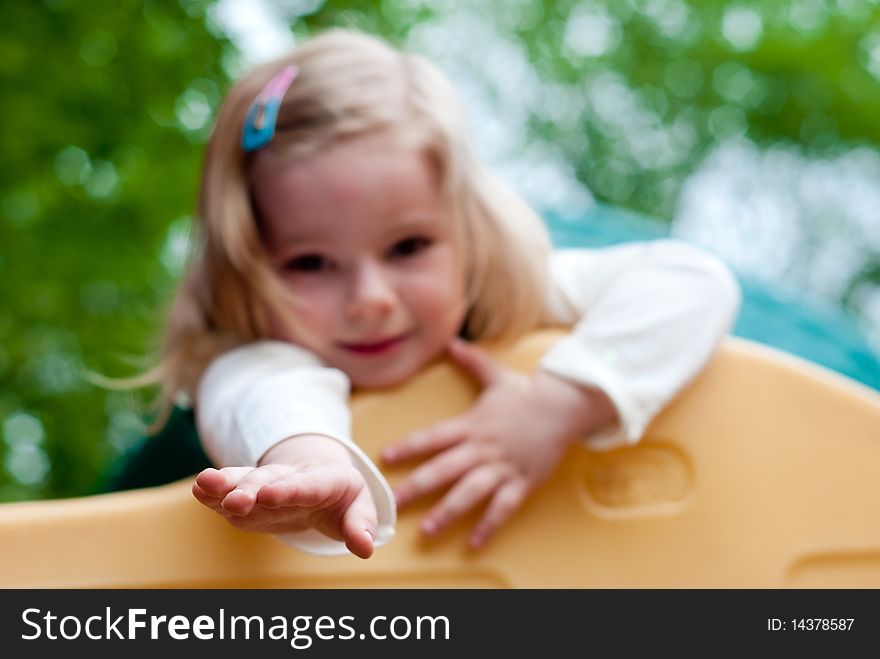 Little smiling girl in the playground. Focus on hand. Little smiling girl in the playground. Focus on hand