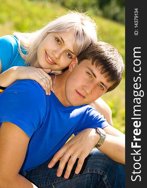 Young couple in the park. Looking At Camera.