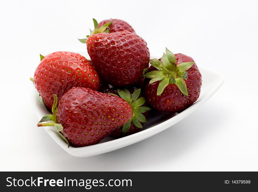 Strawberries on plate on a white background