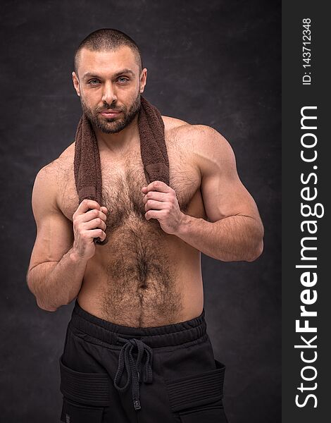 Young Muscular Bodybuilder Man Resting After A Hard Workout Training, Posing With A Towel