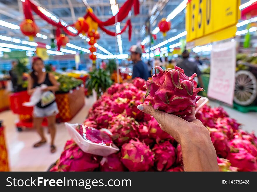 Woman hand with exotic dragon fruit on a local organic food market. Bali island.