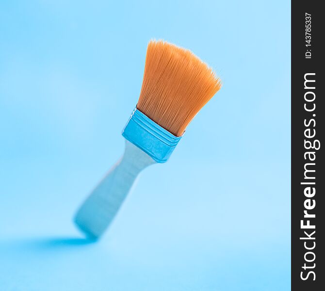 Close up of paint brush isolated on pale blue abstract