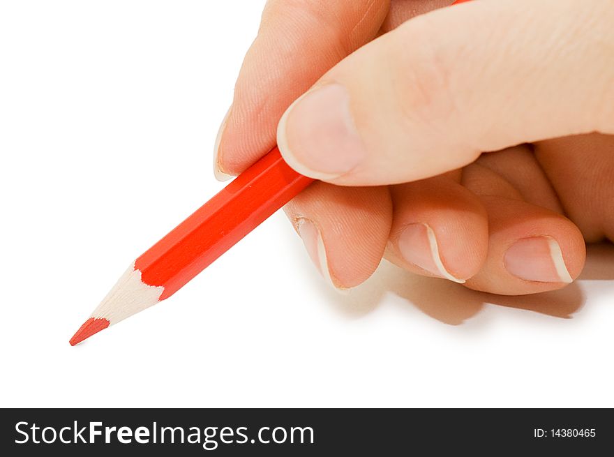 The hand holds a red pencil close up