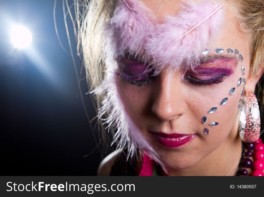 Young stylish teenager with an extreme makeup with feathers and diamonds. Young stylish teenager with an extreme makeup with feathers and diamonds.