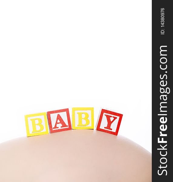 Pregnant belly with wooden playing blocks spelling the word BABY