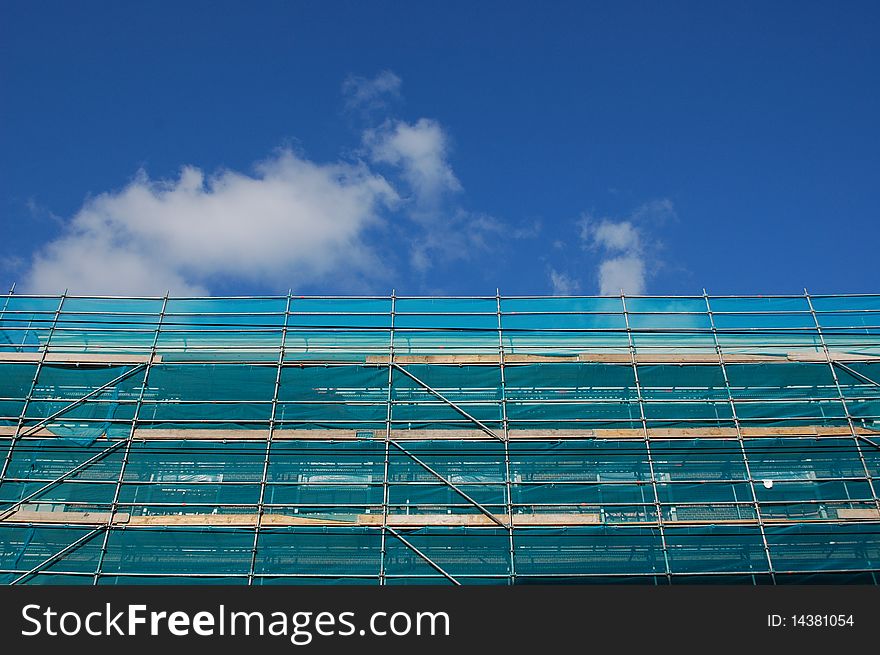 A green scaffold with a blue sky