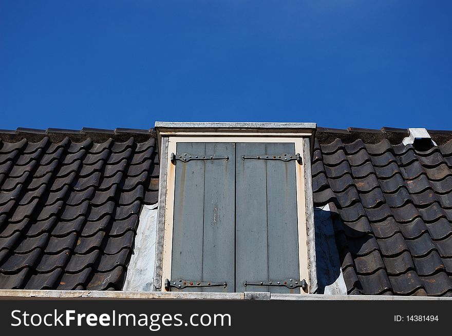 A roof with a door and a blue sky