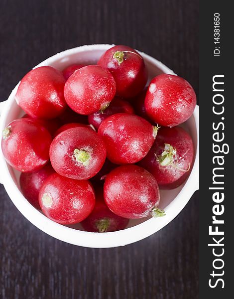 Fresh garden radishes in a white bowl