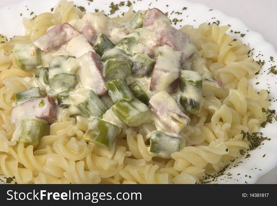 Pasta fusilli served with asparagus and smoked ham in creamy sauce with cram and cheese. Pasta fusilli served with asparagus and smoked ham in creamy sauce with cram and cheese