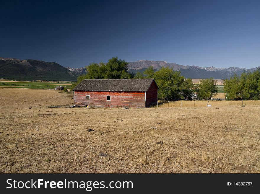 OIld barn in the country side with mountains at the back. OIld barn in the country side with mountains at the back