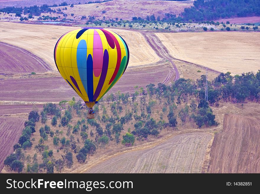 A hot air balloon above fields landscape