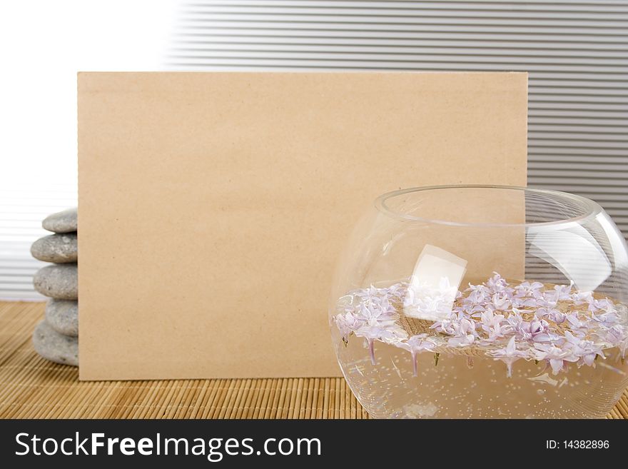 Against the background of rocks and the bowl with water and flowers, a clean sheet of brown paper. Against the background of rocks and the bowl with water and flowers, a clean sheet of brown paper