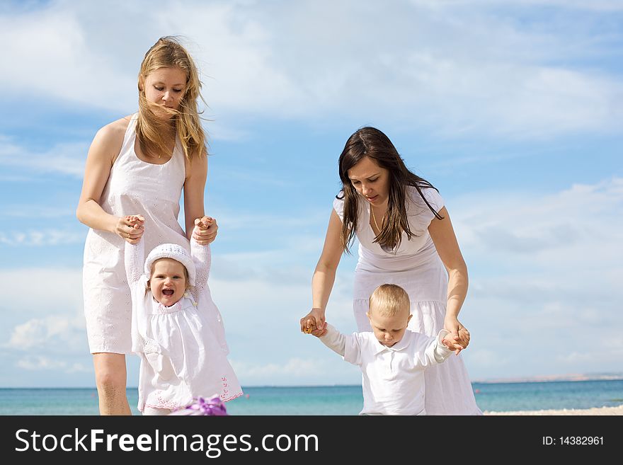 Happy Mothers With Children At The Beach