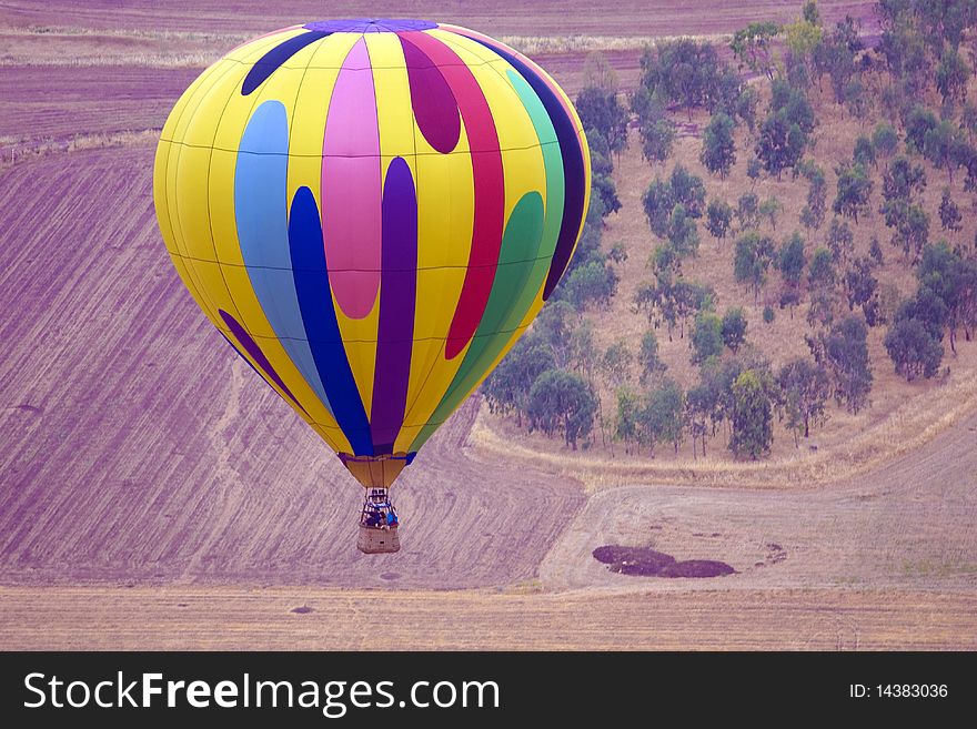 A hot air balloon above fields landscape