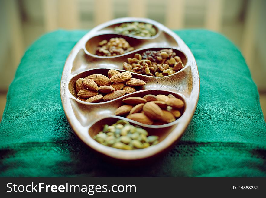 Walnuts and almonds in the wooden dish (shallow DOF). Walnuts and almonds in the wooden dish (shallow DOF)