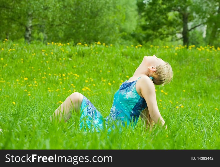 Sweet  long-haired girl rests on the grass