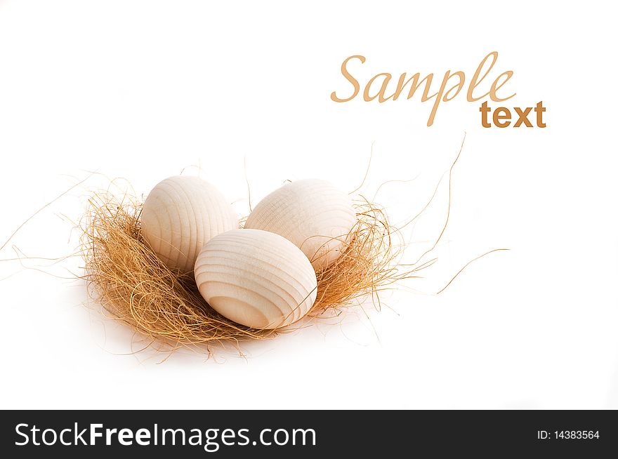 Decorative eggs lying on some hay isolated on white