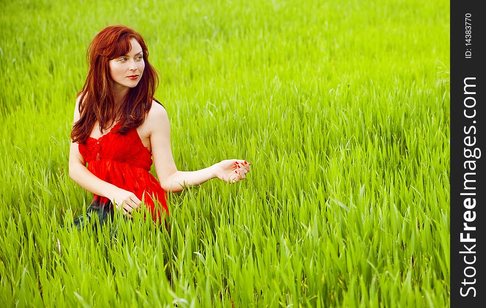 Woman in red enjoying nature in a green field. Woman in red enjoying nature in a green field