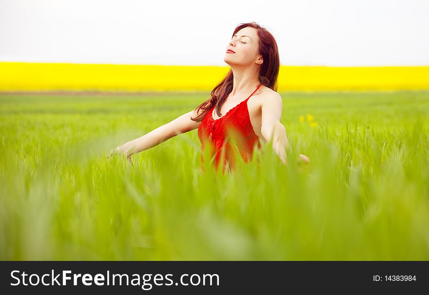 Woman in red enjoying nature in a green field. Woman in red enjoying nature in a green field