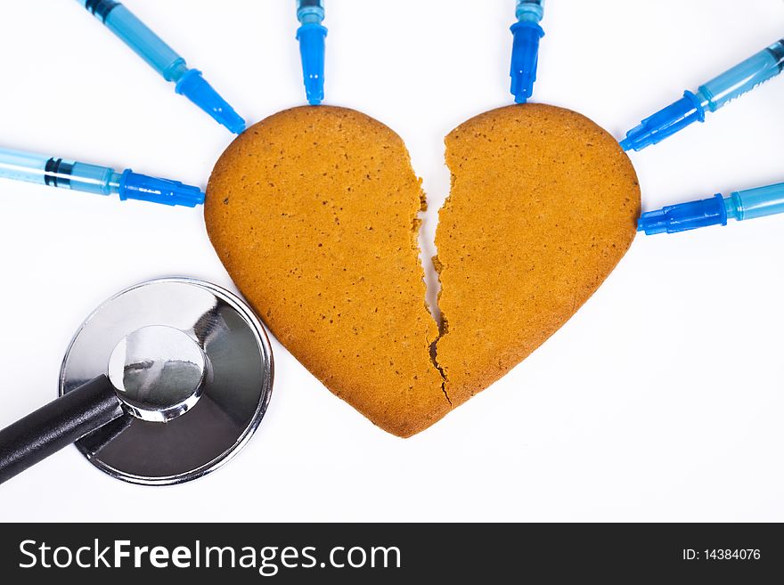 Healing a broken heart with blue syringe and a stethoscope on white background