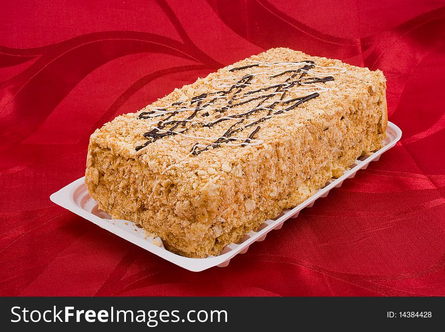 View of a chocolate cake on red background. View of a chocolate cake on red background.