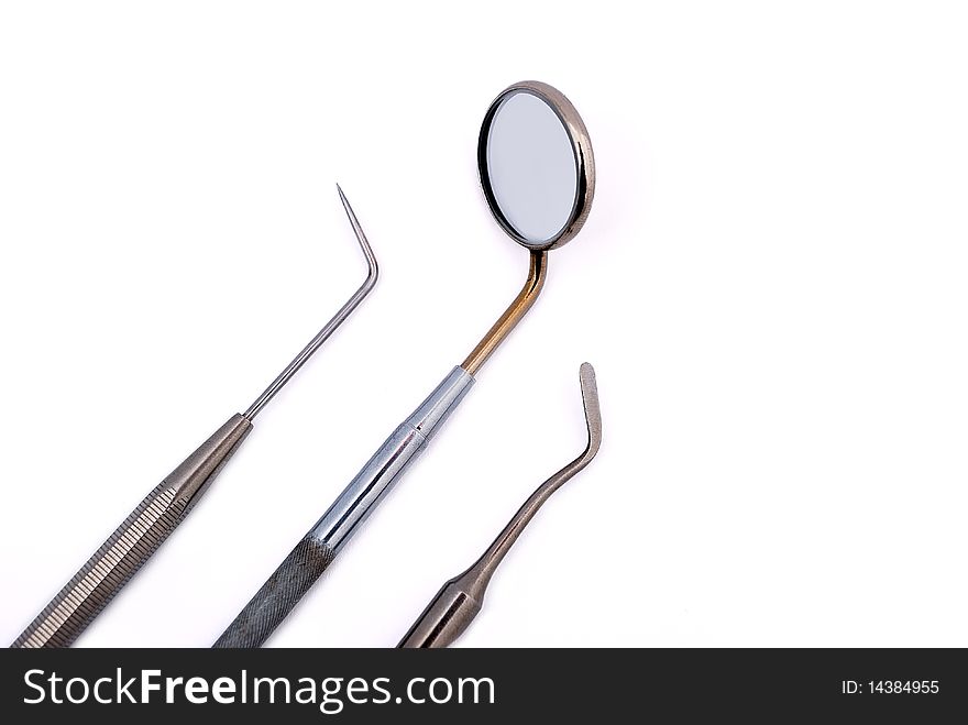 Dental tools: oral mirror, tweezers and spatula on white background