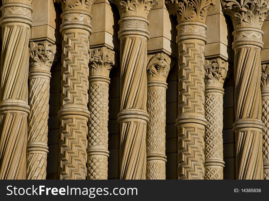 Row of columns of Natural History Museum in London. Sandy color of symmetry columns with details of architecture and fretwork. Row of columns of Natural History Museum in London. Sandy color of symmetry columns with details of architecture and fretwork.