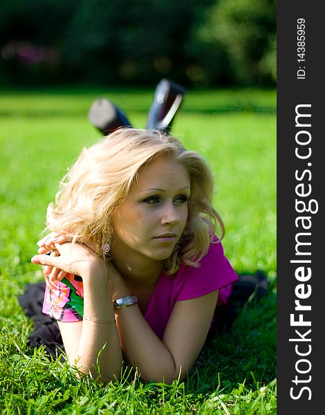 Young beautyful girl lying on grass on a sunny day in a park. Young beautyful girl lying on grass on a sunny day in a park