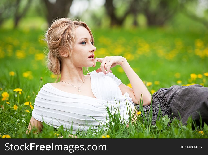 Blond girl relaxing in dandelions